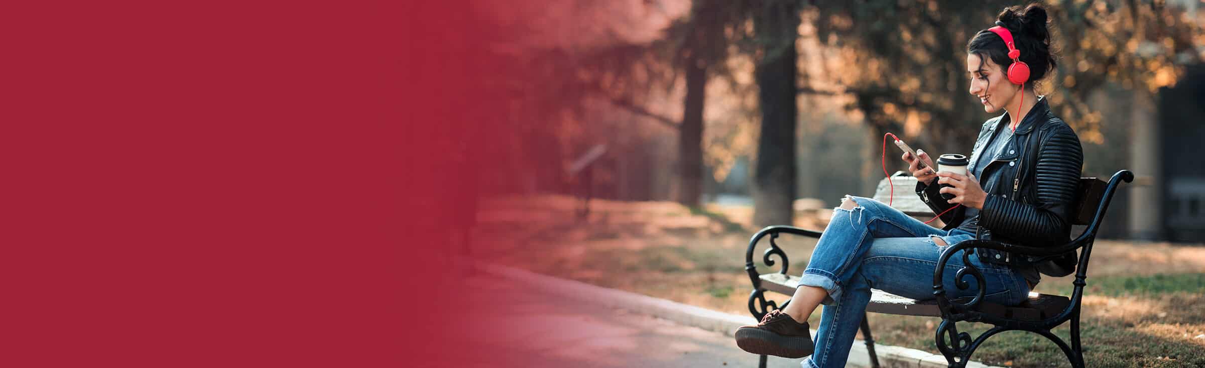 woman sitting on bench using device