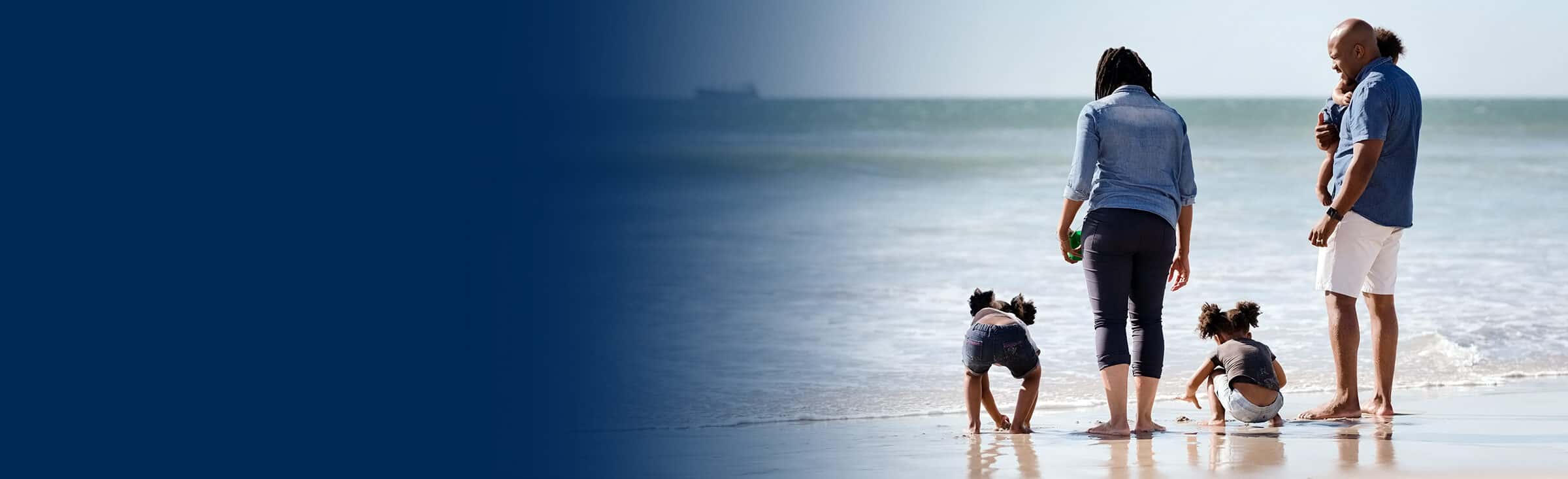 a young family with three children plays on the beach
