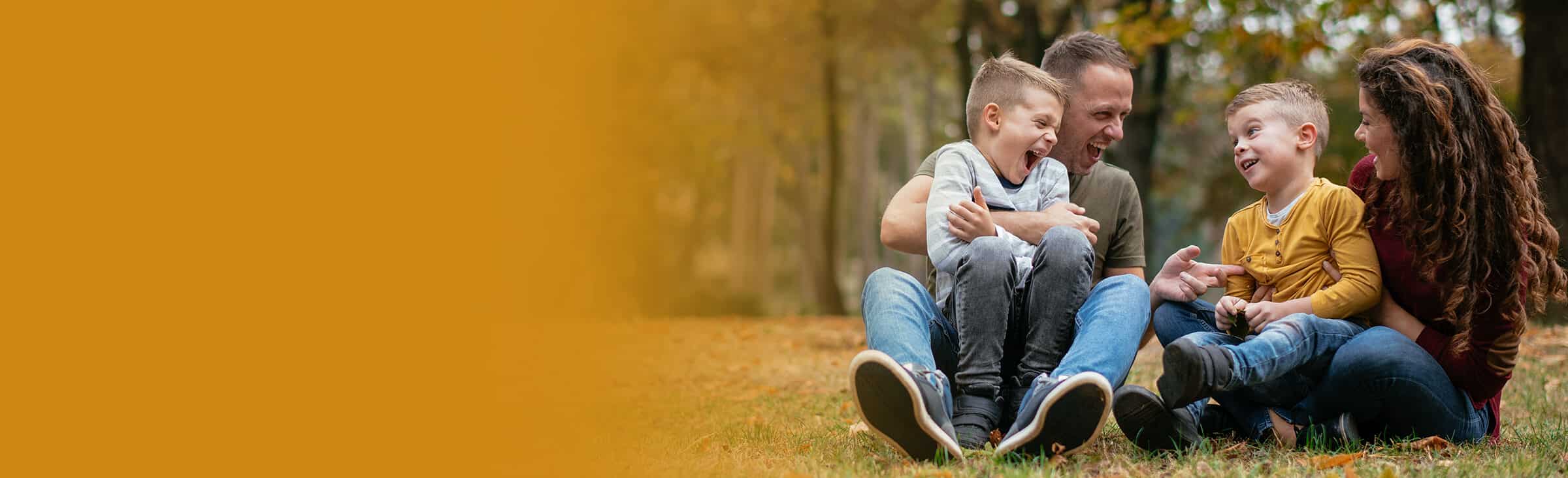 A young family sits in a park