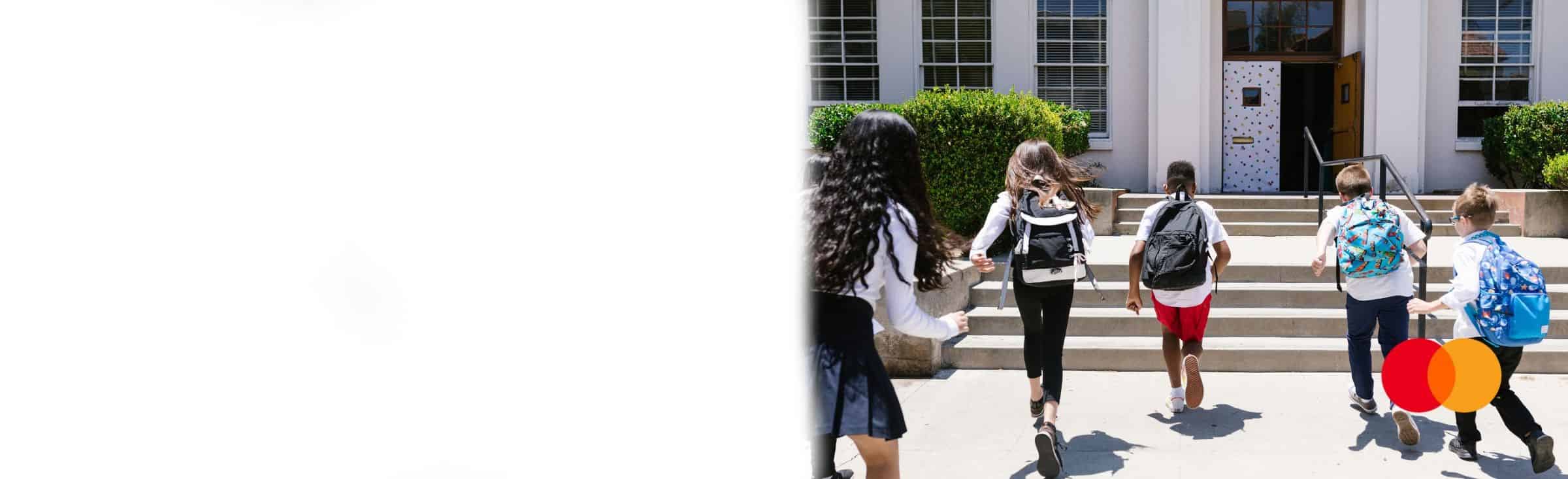 Students running up steps into school.